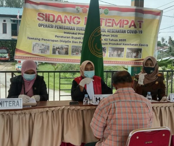 Salah seorang warga yang terjaring razia masker menjalani sidang di tempat di depan Kantor Kecamatan Pangkalan Kuras, Kamis (22/10/2020). Foto: Istimewa.