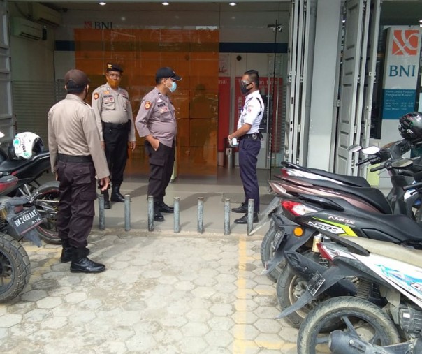 Personel Polsek Pangkalan Kerinci saat berkomunikasi dengan Satpam BNI, Jumat (23/10/2020). Foto: Istimewa.