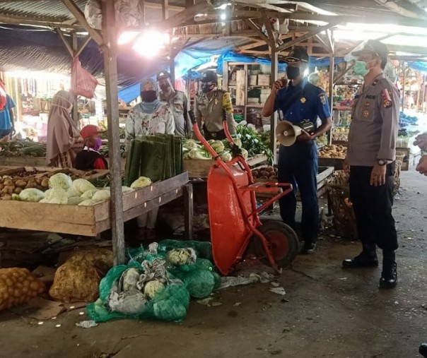 Personel Polsek Pangkalan Kuras dan Satpol PP Kabupaten Pelalawan saat Operasi Yustisi di pasar, Selasa (27/10/2020). Foto: Istimewa.