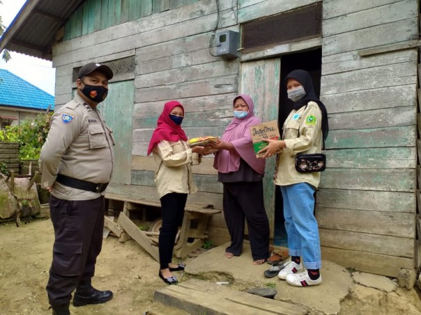 Personel Polres Inhu bersama mahasiswa STIE Indragiri Rengat membagikan paket Sembako kepada warga yang terdampak Pandemi Covid-19.