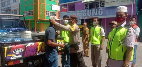 Personel Polres Inhu bersama tim relawan membagikan masker kepada warga Kota Rengat