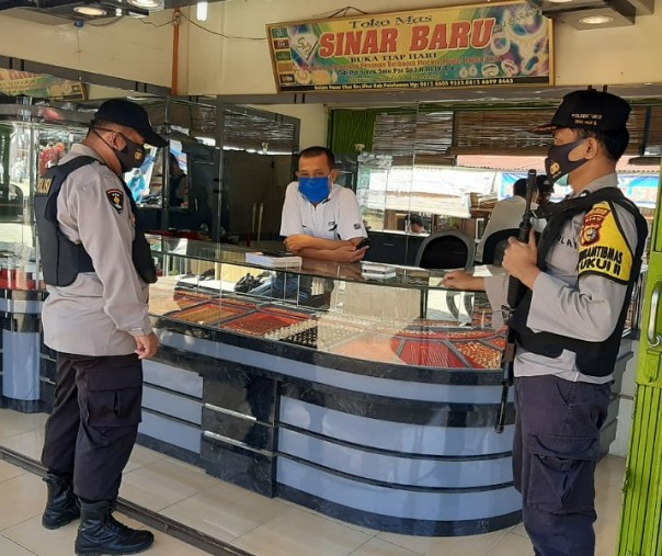 Personel Polsek Ukui saat patroli di toko mas, Jalan Lintas Timur Kabupaten Pelalawan, Kamis (29/10/2020). Foto: Istimewa.