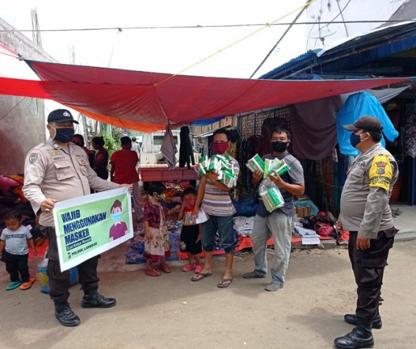 Personel Polsek Langgam saat mensosialisasikan protokol kesehata di Desa Segati, Kabupaten Pelalawan, Minggu (1/11/2020). Foto: Istimewa.