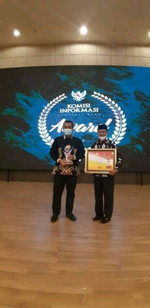 Pjs Bupati Roni Rakhmat dan Kadis Kominfo Kuansing Syamsir Alam saat menerima Penghargaan kI Award/R24