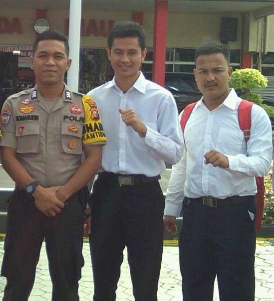 Bhabinkamtibmas Desa Talang Jerinjing, Brigadir Komarudin (kiri) foto bersama dua anak suku talang mamak, Anto dan Andika Swanda