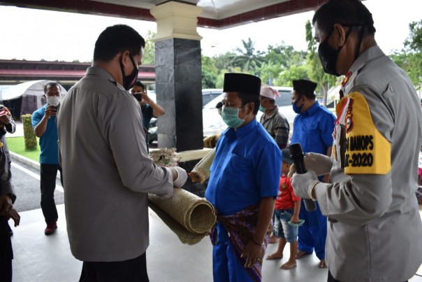 Kapolres Inhu AKBP Efrizal (kiri) menerima cinderamata dari Batin Denan (kanan)