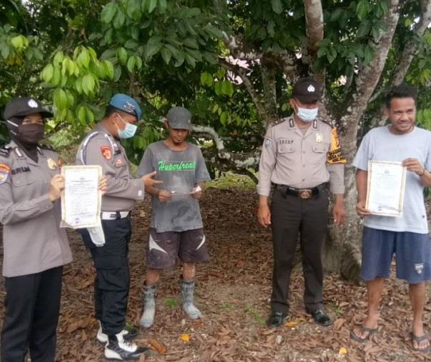 Personel Polsek Pangkalan Kuras saat membagikan Maklumat Kapolda Riau kepada masyarakat Kelurahan Sorek, Rabu (25/11/2020). Foto: Istimewa.