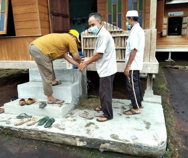 Pendukung salah satu paslon cakada Pelalawan saat mencuci tangan sebelum masuk ke lokasi kampanye, Kamis (26/11/2020). Foto: Istimewa.