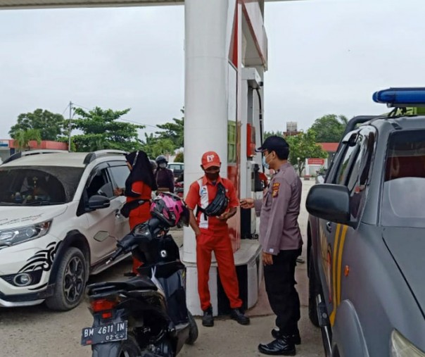 Personel Polsek Pangkalan Kerinci saat berbincang dengan karyawan SPBU mengenai situasi terkini, Sabtu (28/11/2020). Foto: Istimewa.