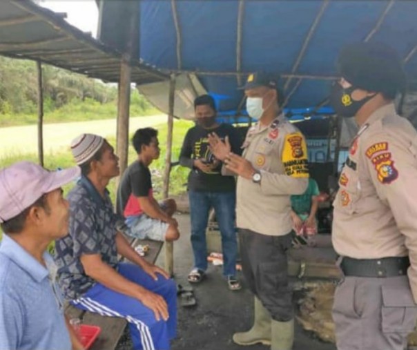 Bhabinkamtibmas Polsek Teluk Meranti mensosialisasikan protokol kesehata  ke Desa Pulau Muda, Kabupaten Pelalawan, Sabtu (28/11/2020). Foto: Istimewa.