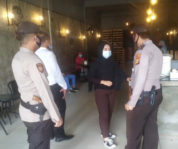 Personel Polsek Pangkalan Kerinci saat berbincang dengan pemilik kafe, Senin (30/11/2020). Foto: Istimewa.