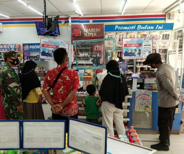 Personel Polsek Kerumutan dan TNI saat berpatroli dengan karyawan swalayan Indomaret, Senin (30/11/2020). Foto: Istimewa.