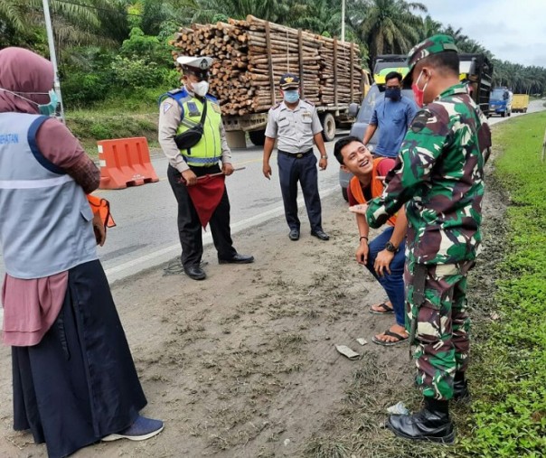 Petugas gabungan mendapati seorang warga tak mengenakan masker saat Operasi Yustisi di Desa Simpang Beringin, Pelalawan, Rabu (2/12/2020). Foto: Istimewa. 