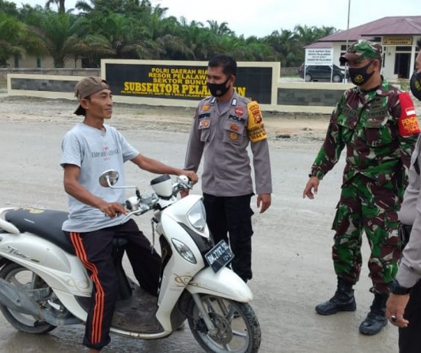 Seorang pengendara motor yang tak mengenakan masker terjaring Operasi Yustisi di depan Mapolsubsektor Pelalawan, Rabu (2/12/2020). Foto: Istimewa.