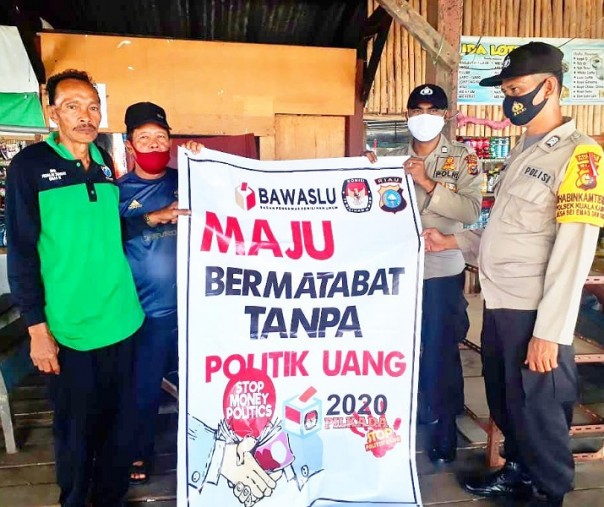 Personel Polsek Ukui mensosialisasikan tolak politik uang di warung yang dijadikan tempat tunggu penumpang speedboat, Kamis (3/12/2020). Foto: Istimewa. 