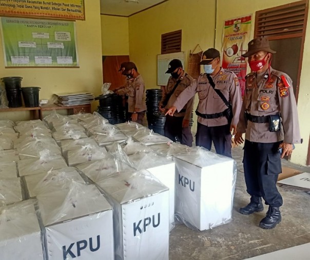 Kapolsek Bunut AKP Rokhani bersama personelnya mengecek surat suara Pilkada Pelalawan di PPK Kecamatan Bunut dan Kecamatan Bandar Petalangan, Kamis (10/12/2020). Foto: Istimewa.