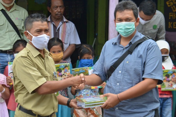 (Pimpinan SSD PT Arara Abadi-Sinar Mas Forestry, Deny Widjaya Foto bersama stelah menyerahkan secara simbolis paket Juz Amma dan Buku Tulis Sinar Dunia untuk Anak-anak Sakai dari PT Arara Abadi – APP Sinar Mas kepada Sekretaris Desa Kampung Minas barat)