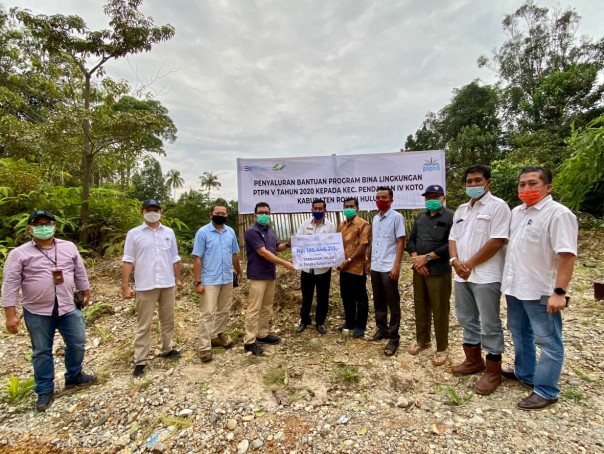 SEVP Business Support PTPN V Rurianto menyerahkan bantuan dana bina lingkungan untuk peningkatan kualitas jalan kepada Kepala Desa Pendalian Mulyadi, baru-baru ini di Kec. Pendalian IV Koto Rokan Hulu