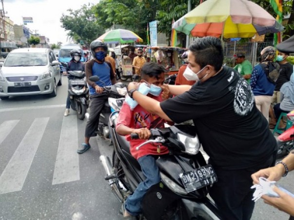 Ketua Foskor Riau, Romai Noor Auni saat kegiatan sosial berbagi masker gratis di Jalan Harapan Raya depan Kantor Lurah Tangkerang Selatan, Pekanbaru 