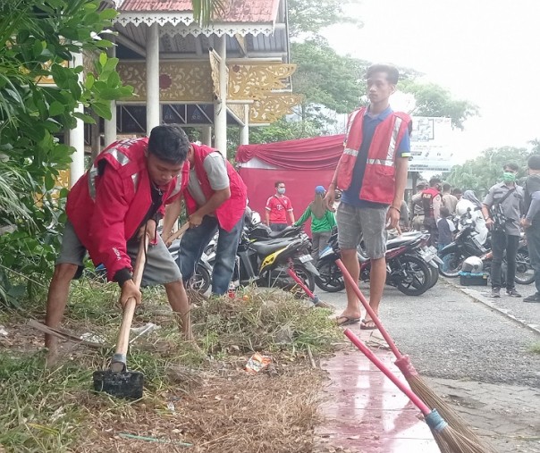 Seorang bocah juga ikut dihukum kerja sosial dalam razia masker di gerbang Kawasan Purna MTQ Pekanbaru, Kamis (7/1/2021). Foto: Surya/Riau1.