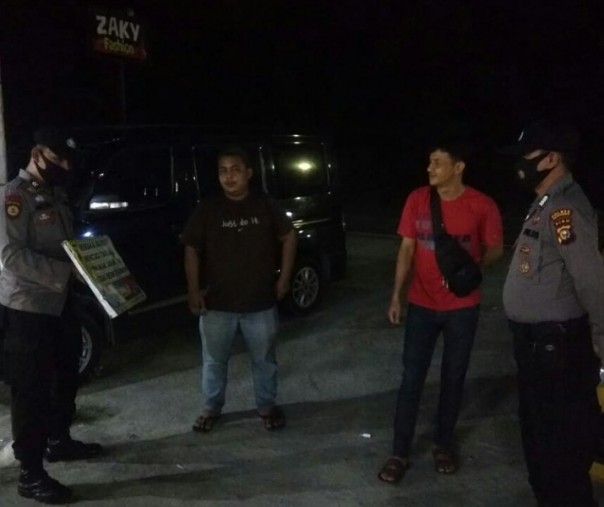 Personel Polsek Bandar Sei Kijang saat sosialisasi prokes kepada pengemudi truk yang beristirahat, Kamis (7/1/2021) malam. Foto: Istimewa. 