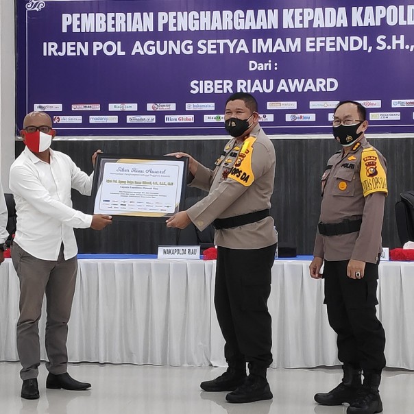 Roy Manurung mewakili 24 media online yang menjadi bagian Siber Riau Award 2020, menyerahkan penghargaan kepada Kapolda Riau Irjen Agung SIE, diwakili Brigjen Tabana Bangun, Selasa 12 Januari 2021.