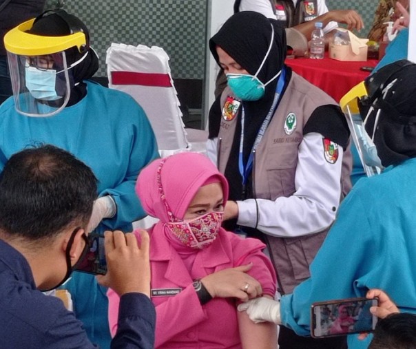 Ervinna, istri Kapolresta Pekanbaru Kombes Nandang Mu'min Wijaya yang juga menjabat Ketua Bhayangkari menjadi wanita pertama yang disuntik vaksin Sinovac di Puskesmas Rejosari, Kamis (14/1/2021). Foto: Istimewa. 