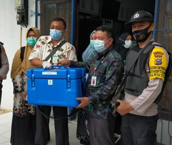 Personel Polsek Bandar Sei Kijang kawal pendistribusian vaksin Sinovac ke Puskesmas Bandar Sei Kijang, Jumat (15/1/2021). Foto: Istimewa.