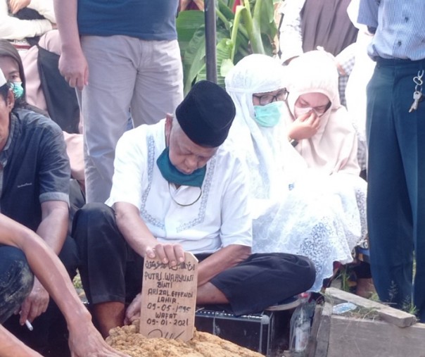 Arizal Effendi, ayahanda Putri Wahyuni, memegang papan nisan anaknya yang menjadi korban pesawat Sriwijaya Air SJ-182, di TPU Jalan Limbungan, Rumbai Timur, Pekanbaru, Minggu (17/1/2021). Foto: Surya/Riau1.