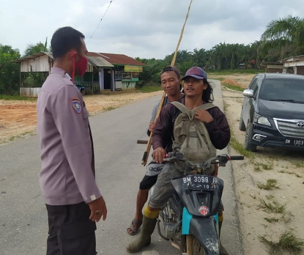 Personel Polsubsektor Pelalawan menemukan pengendara motor tak pakai masker saat Operasi Yustisi di Desa Lalang Kabung, Kabupaten Pelalawan, Minggu (17/1/2021). Foto: Istimewa.