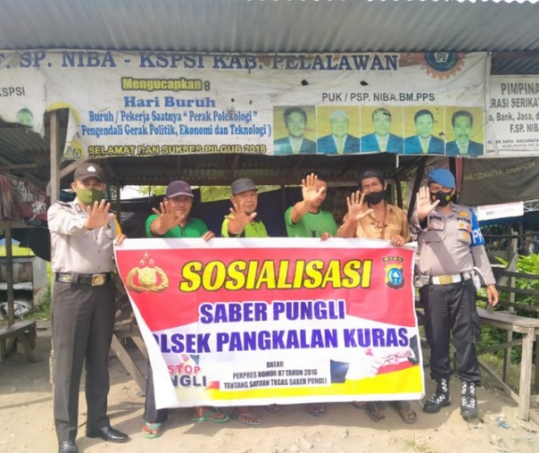 Personel Polsek Pangkalan Kuras saat sosialisasi Saber Pungli kepada buruh bongkar muat, Selasa (19/1/2021). Foto: Istimewa.