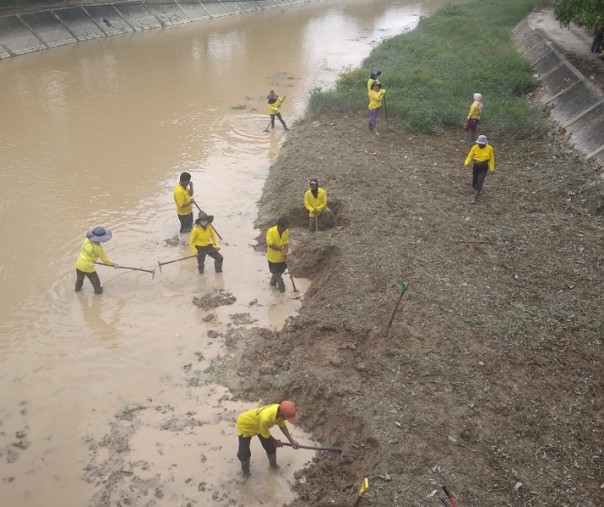 Pasukan kuning (para pekerja Dinas PUPR Pekanbaru) sedang membersihkan endapan tanah di bawah Jembatan Sungai Sail di Jalan Imam Munandar, beberapa waktu lalu. Foto: Surya/Riau1.