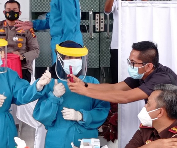 Petugas Puskesmas Rejosari melihat botol kecil vaksin Sinovac yang akan disuntikkan kepada 10 pejabat dan tokoh agama pada 14 Februari 2021 lalu. Foto: Surya/Riau1.