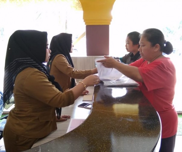 Warga melihatkan kelengkapan dokumen kependudukan di Kantor Disdukcapil Pekanbaru. Foto: Surya/Riau1.