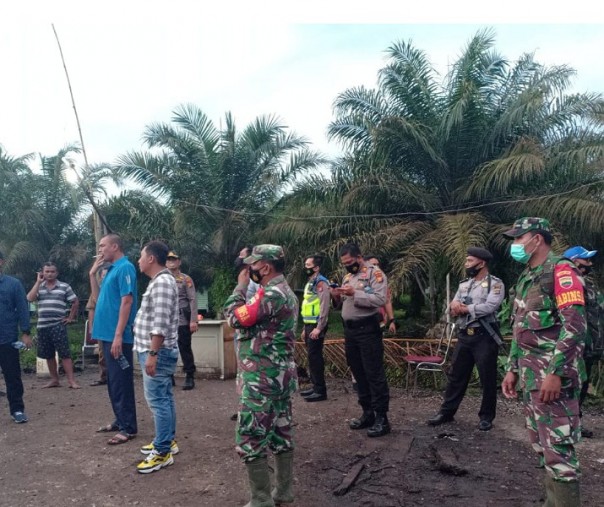 Polisi dan TNI menjaga lokasi kebun sawit milik Puskopkar Riau di Desa Sontang, yang diserang 30-an OTK, Selasa (26/1/2021). Foto: Istimewa. 