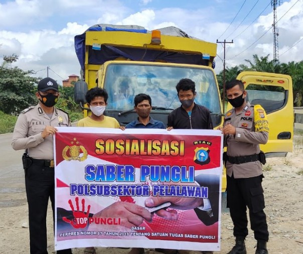 Personel Polsubsektor Pelalawan sosialisasi Saber Pungli ke sopir truk, Sabtu (6/2/2021). Foto: Istimewa. 