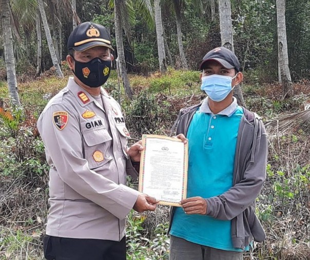 Kapolsek Kuala Kampar AKP Hanova Siagian saat memberikan Maklumat Kapolda Riau soal larangan karhutla ke warga, Selasa (9/2/2021). Foto: Istimewa.