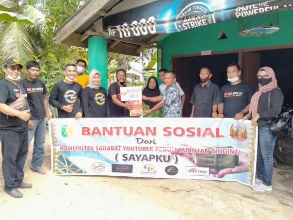 Ketua Komunitas Sayapku Madiyusman didampingi Kades Pulau Busuk Jaya Suryadi Putra saat menyerahkan bantuan sembako untuk orang jompo/Ist