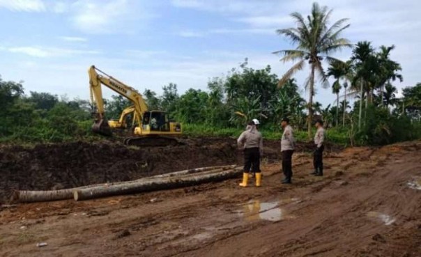 Petugas kepolisian saat mengamankan pembebasan lahan tol/Langgam.id