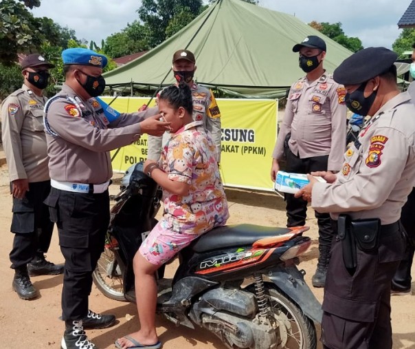 Polsek Pangkalan Lesung saat memasangkan masker ke pengendara yang masuk pasar, Sabtu (27/2/2021). Foto: Istimewa.