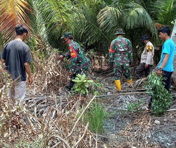 Personel Polsek Kerumutan bersama TNI AD saat membagikan masker ke pengendara, Minggu (28/2/2021). Foto: Istimewa. 