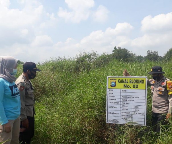 Personel Polsek Pangkalan Kerinci melaksanakan pengecekan kanal blocking, Minggu (28/2/2021). Foto: Istimewa. 