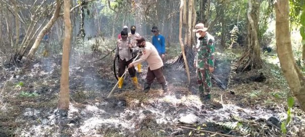 Petugas gabungan melakukan pendinginan pada lahan yang terbakar