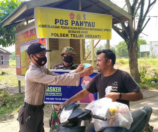 Polsek Teluk Meranti bersama TNI membagikan masker di Posko Terpadu PPKM berskala mikro di Jalan Lintas Bono, Senin (1/3/2021). Foto: Istimewa. 