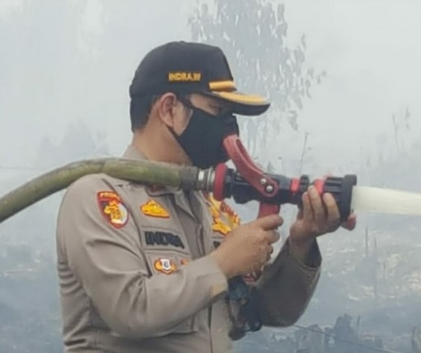 Kapolres Pelalawan AKBP Indra Wijatmiko berjibaku melakukan pendinginan di lokasi karhutla yang terjadi di Kecamatan Teluk Meranti, Selasa (2/3/2021). Foto: Istimewa.