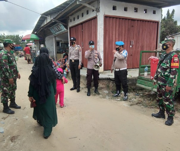 Personel Polsek Kerumutan Operasi Yustisi bersama TNI AD di pasar Desa Bukit Lembah Subur, Sabtu, (6/3/2021). Foto: Istimewa.