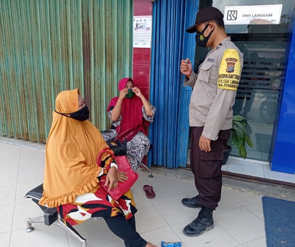 Personel Polsek Langgam saat sosialisasi prokes ke warga Desa Segati, Senin (8/3/2021). Foto: Istimewa. 