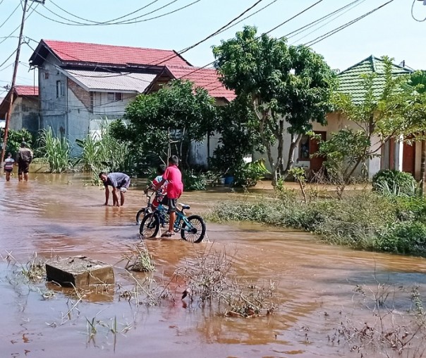Anak-anak bermain sepeda di tengah banjir yang sudah mulai surut di Perumahan Graha Fauzan, Kelurahan Tangkerang Lantai, Kecamatan Bukit Raya, Selasa (30/3/2021). Foto: Istimewa. 