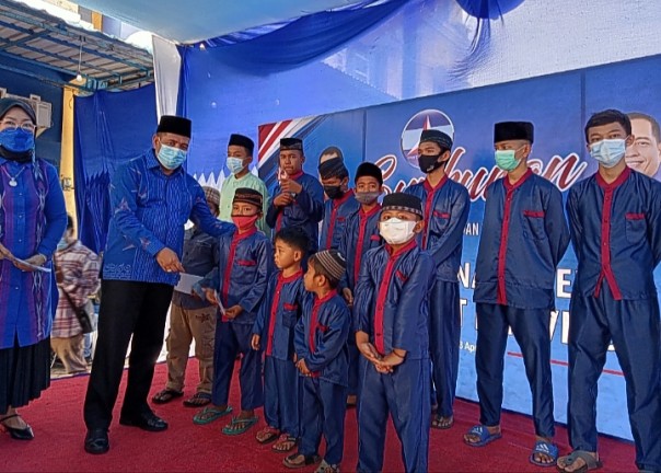 Ketua DPD Demokrat Riau Asri Auzar menyerahkan santunan pada anak Yatim