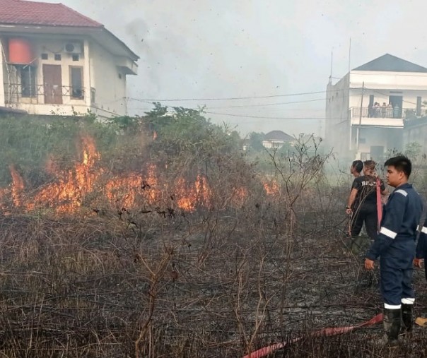 Petugas BPBD Pekanbaru saat memadamkan kebakaran lahan di Gang Mulya Sari, Kelurahan Tangkerang Selatan, Senin (5/4/2021). Foto: BPBD. 